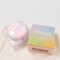 MaquiMarket Polvo translúcido fijador Majikal Beauty con aplicador rosa y caja arcoíris. Acabado mate.